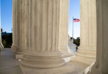 View of marble columns with an American flag in the background