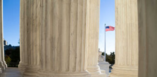View of marble columns with an American flag in the background