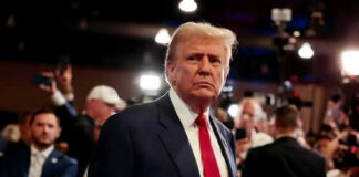 Man in suit with red tie at crowded event