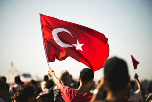 Person waving Turkish flag in a crowd
