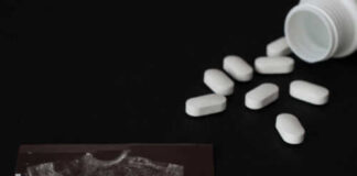 Ultrasound image and spilled white pills on black background
