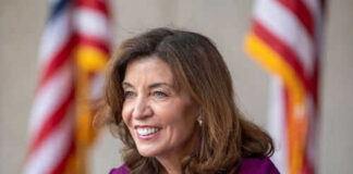 Smiling woman in a purple dress with flags behind