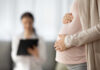 Doctors Stuck in Legal Quicksand Post-Dobbs Pregnant person holding their belly during a medical visit