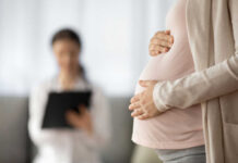 Doctors Stuck in Legal Quicksand Post-Dobbs Pregnant person holding their belly during a medical visit