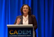 A woman speaking at a podium for the California Democratic Party