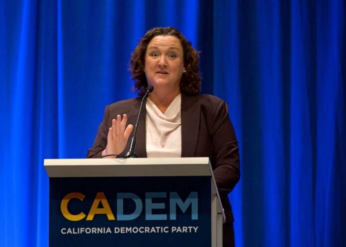A woman speaking at a podium for the California Democratic Party