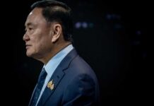 Profile portrait of a man in formal attire with a pin on his lapel
