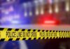 Yellow police caution tape with the text 'POLICE LINE DO NOT CROSS' in a blurred background
