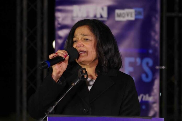 A woman speaking into a microphone at an outdoor event