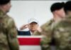 Trump $250 Note? Congress Holds the Power A man in a USA hat saluting during a military ceremony