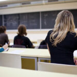 Students seated in a classroom listening to a teacher