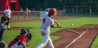 Baseball batter in white uniform hitting a pitched ball