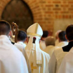 $300M Shock: Parish Wallets On The Line Clerics in white robes facing altar in church