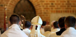 Clerics in white robes facing altar in church