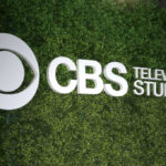 CBS Television Studios logo on green hedge backdrop