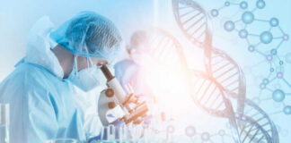 Scientist in protective gear using a microscope in a laboratory