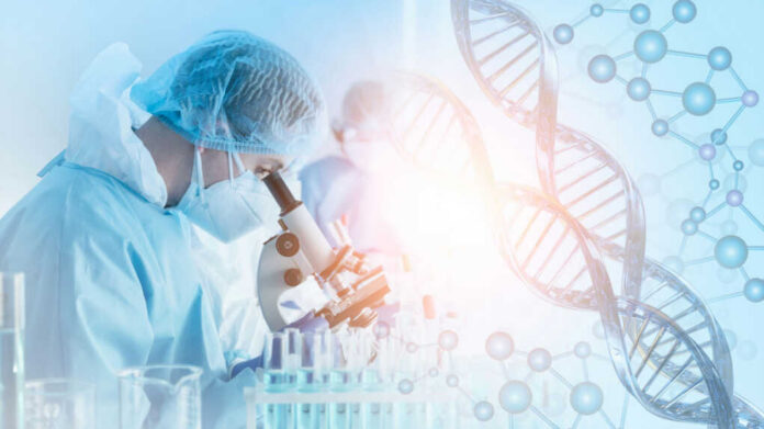 Scientist in protective gear using a microscope in a laboratory