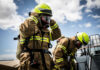 Inmates On The Frontlines — California Cashes In On Captive Crews Firefighters in protective gear standing outside cloudy sky