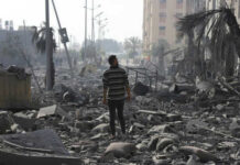 Ceasefire ‘All Fronts’ Claim—But Not Gaza? Person walking through rubblestrewn street in daylight