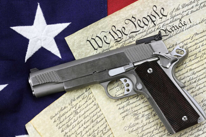 Pistol on Constitution and flag background.