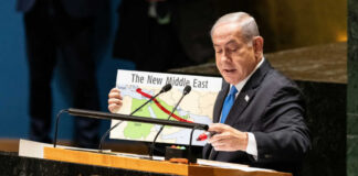 Speaker at UN podium holding a Middle East map