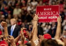 MAGA Isn’t Fracturing — Polls Show Frustration, Not Collapse Crowd holding red Make America Great Again sign