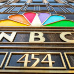 Cable Empire Cracks — Comcast Flinches NBC logo with colorful peacock design.