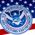 Homicide, Suicide, TB — At One U.S. Camp Seal of U.S. Immigration and Customs Enforcement on an American flag background