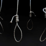 Four nooses hanging against a dark background