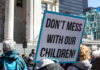 Protest sign held at a rally in an urban square
