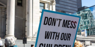 Protest sign held at a rally in an urban square
