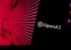 Close-up of a smartphone displaying the OpenAI logo against a vibrant digital background