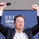 Warren Moves To Stall Musk’s Moonshot Person with a microphone raising hands in celebration