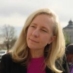 Woman with blonde hair outdoors near a government building