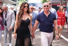 Billionaire Glow-Up Sparks HGH Whispers Man in a suit smiling outdoors.