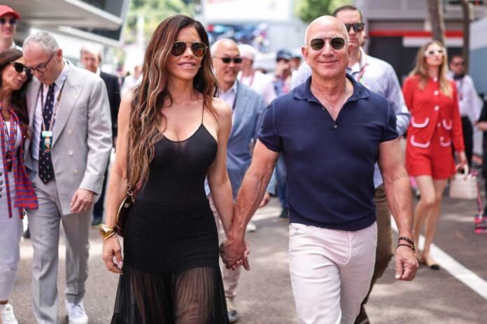 Amazon,Founder,Jeff,Bezos,Walks,With,Lauren,Sanchez,In,The Man in a suit smiling outdoors.