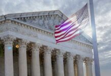 SCOTUS Showdown: AR-15 Rights On Trial The Supreme Court building with an American flag waving in front
