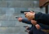 Hands holding pistols at a firing range