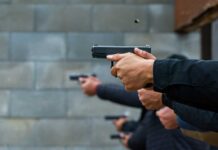Hands holding pistols at a firing range