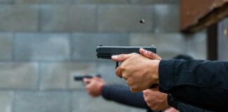 Hands holding pistols at a firing range