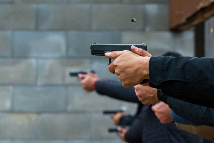 Hands holding pistols at a firing range