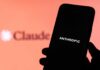 Jailbreak Panic Triggers Global Blackout A hand holding a smartphone displaying the word 'ANTHROPIC' against a blurred background