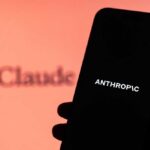 Jailbreak Panic Triggers Global Blackout A hand holding a smartphone displaying the word 'ANTHROPIC' against a blurred background