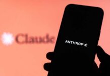 Jailbreak Panic Triggers Global Blackout A hand holding a smartphone displaying the word 'ANTHROPIC' against a blurred background