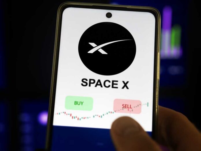 Person checking stock market graphs on phone and monitors.