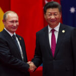 U.S. Blunder Forges China–Russia Power Axis Two international leaders shaking hands at a diplomatic event