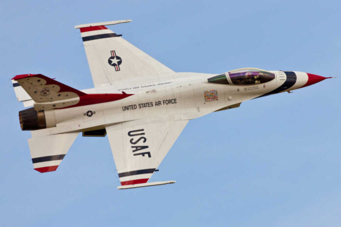 USAF fighter jet in flight with red, white, and blue livery