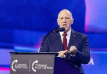 “Flood the Zone”: ICE Surge Coming to New York Person speaking at Turning Point USA event podium