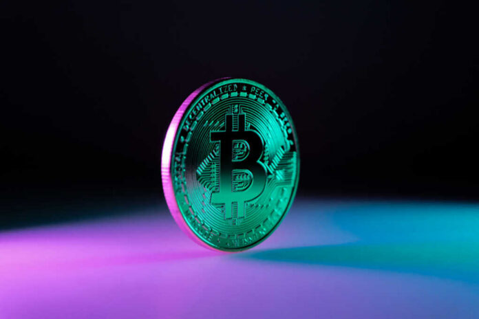 Bitcoin-token_2464800449 Green Bitcoin coin on purple and blue background