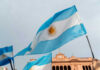 FIFA Hypocrisy Erupts On World Stage Argentinian flag with sun emblem waving above a historic building